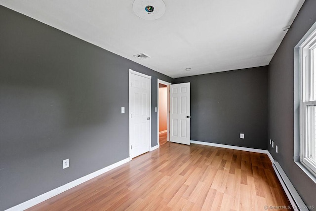 99 Redwood Dr, Bristol, CT 06010 - spare room with a baseboard heating unit, light wood-type flooring, and baseboards