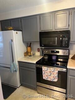 26 Guiel Pl Apt 5, Meriden, CT 06450 - kitchen featuring stainless steel range with electric stovetop, black microwave, freestanding refrigerator, light countertops, and gray cabinets