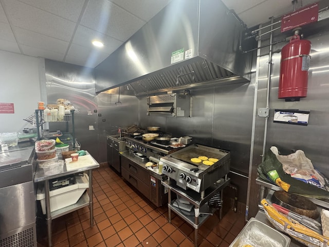 kitchen with dark tile patterned floors, island range hood, and a paneled ceiling