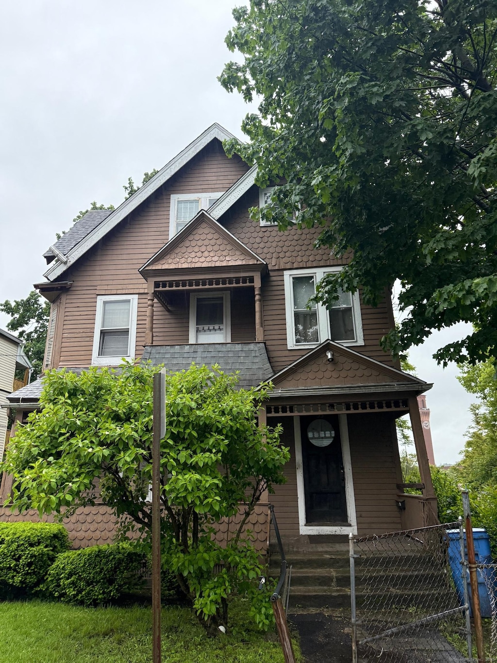 33 Mitchell Ave, Waterbury, CT 06710 - victorian home with a fenced front yard, covered porch, and roof with shingles