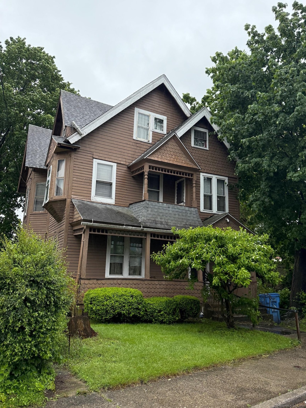 33 Mitchell Ave, Waterbury, CT 06710 - victorian home with roof with shingles, stone siding, and a front lawn