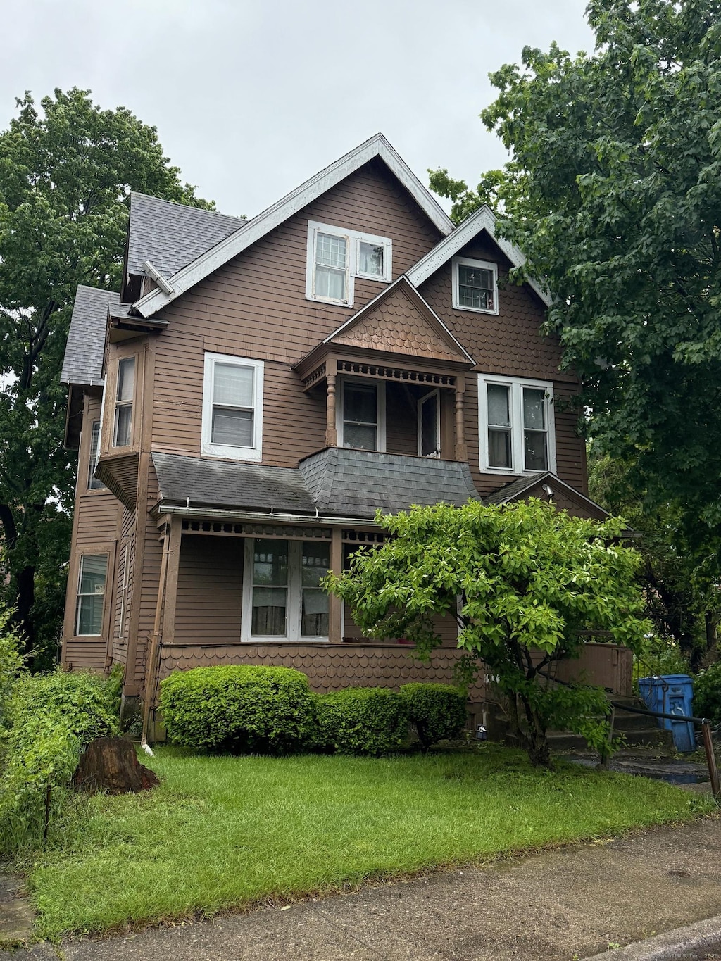 33 Mitchell Ave, Waterbury, CT 06710 - victorian home with a shingled roof, stone siding, and a front yard