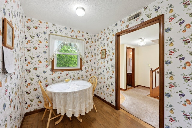 1277 New Britain Ave Unit 1277, West Hartford, CT 06110 - dining room featuring wood finished floors, wallpapered walls, a textured ceiling, and baseboards