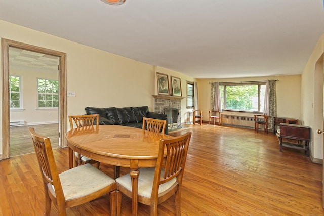 246 Ray Rd, New Haven, CT 06515 - dining area with radiator heating unit, light wood finished floors, a baseboard radiator, and a fireplace