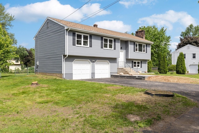 447 Palisado Ave, Windsor, CT 06095 - split foyer home featuring a chimney, driveway, and an attached garage