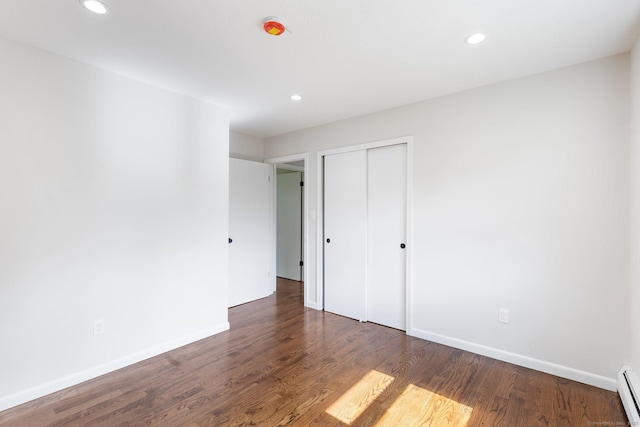 447 Palisado Ave, Windsor, CT 06095 - unfurnished bedroom with a baseboard radiator, baseboards, recessed lighting, wood finished floors, and a closet