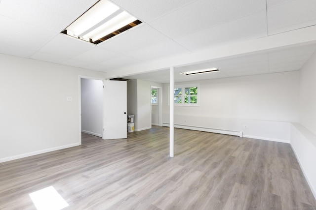 447 Palisado Ave, Windsor, CT 06095 - below grade area with a baseboard radiator, light wood-style flooring, baseboards, and a paneled ceiling