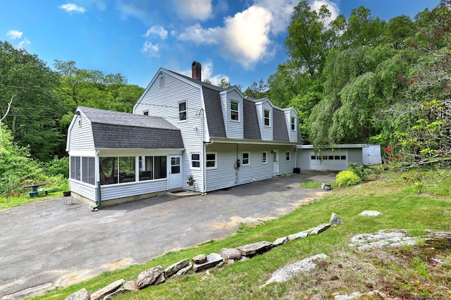 8 Whippoorwill Ln, Bethany, CT 06524 - back of property with a gambrel roof, driveway, roof with shingles, a chimney, and a sunroom