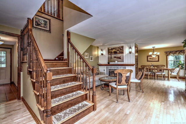 8 Whippoorwill Ln, Bethany, CT 06524 - stairway featuring a fireplace, plenty of natural light, hardwood / wood-style flooring, and a chandelier
