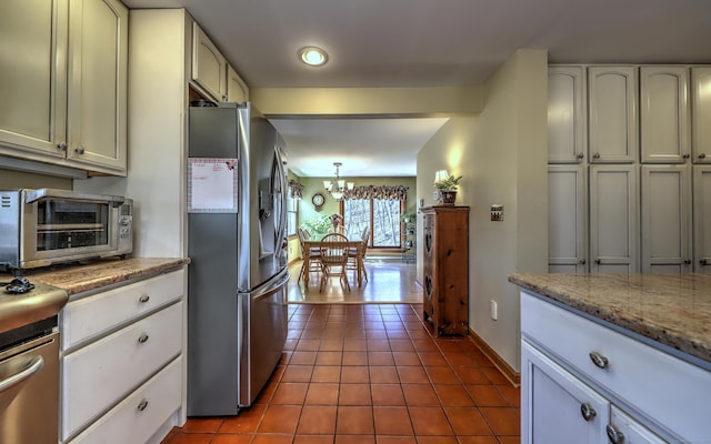 8 Whippoorwill Ln, Bethany, CT 06524 - kitchen featuring stainless steel refrigerator with ice dispenser, a chandelier, dark tile patterned floors, baseboards, and range