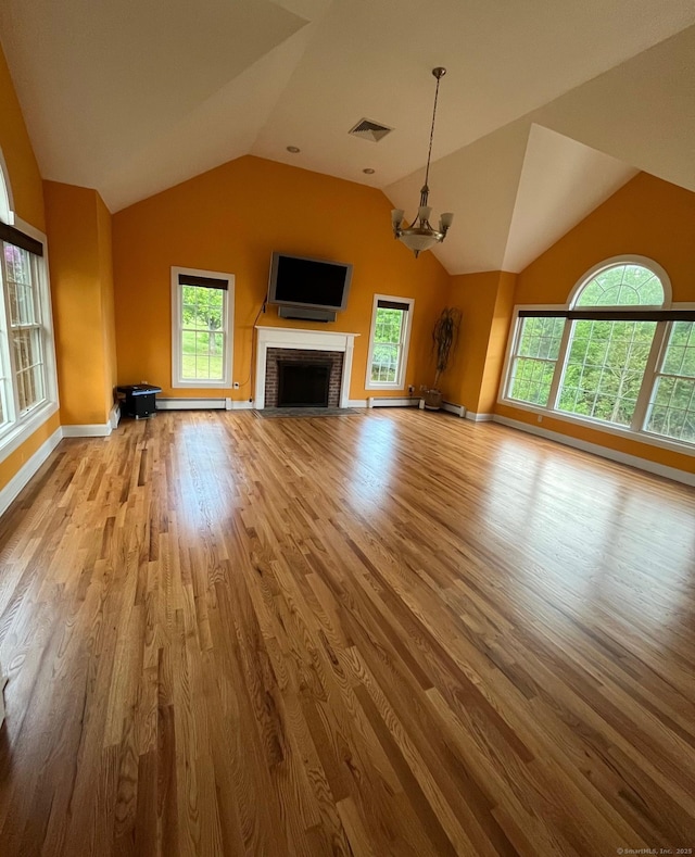 41 Mesa Dr, Bethany, CT 06524 - unfurnished living room featuring wood finished floors, vaulted ceiling, plenty of natural light, baseboards, and a fireplace