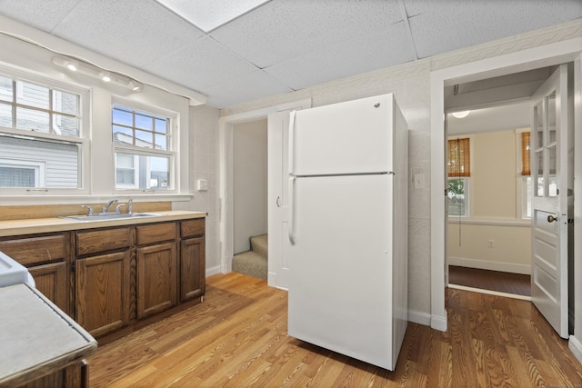128 Grove Pl, West Haven, CT 06516 - kitchen with freestanding refrigerator, a sink, light wood-style flooring, light countertops, and a paneled ceiling