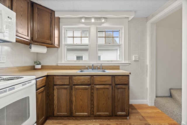 128 Grove Pl, West Haven, CT 06516 - kitchen featuring a sink, white appliances, light wood-style floors, light countertops, and tasteful backsplash