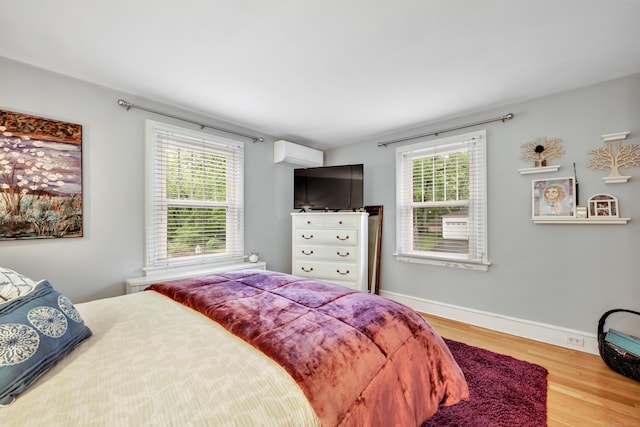 1 Stevens Rd, Middlebury, CT 06762 - bedroom featuring wood finished floors, a wall unit AC, multiple windows, and baseboards