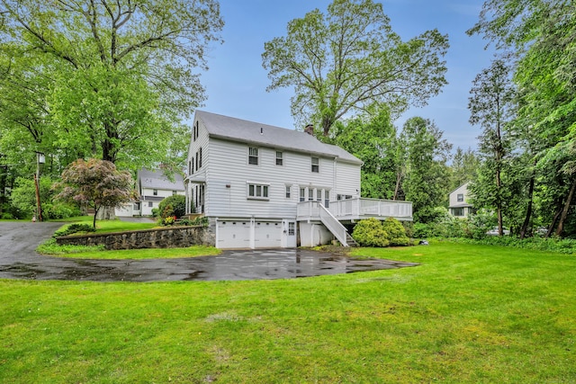 1 Stevens Rd, Middlebury, CT 06762 - back of house with an attached garage, asphalt driveway, a chimney, a yard, and a deck