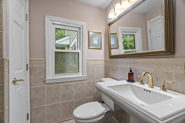 238 Park Rd, Oxford, CT 06478 - bathroom featuring tile walls, healthy amount of natural light, toilet, wainscoting, and a sink