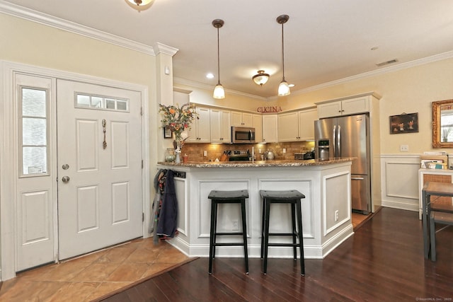 95 S Ridge Ln Unit A203, Berlin, CT 06037 - kitchen with stainless steel appliances, a peninsula, crown molding, light stone counters, and dark wood-style flooring