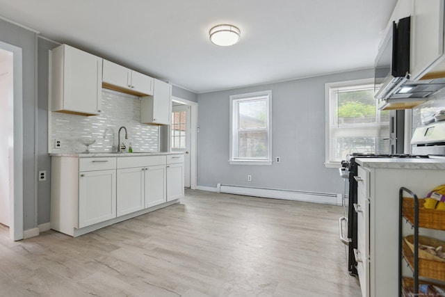 8 3rd St, Norwich, CT 06360 - kitchen with baseboard heating, gas range oven, light countertops, light wood finished floors, and a sink