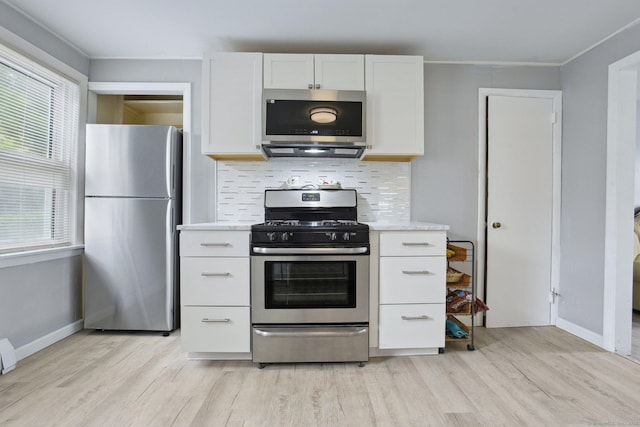 8 3rd St, Norwich, CT 06360 - kitchen with stainless steel appliances, light wood-type flooring, backsplash, white cabinetry, and ornamental molding