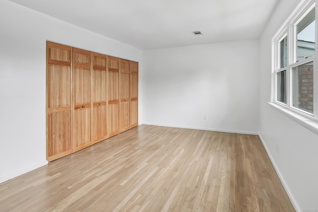 77 Shea Ave Unit 77, Milford, CT 06460 - unfurnished bedroom with light wood finished floors, baseboards, and a closet