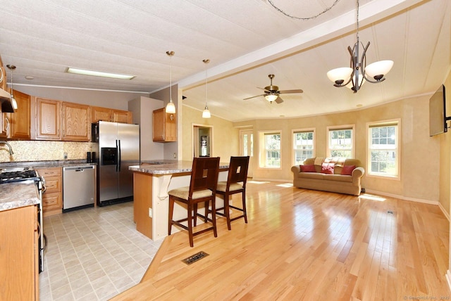 107 Colchester Commons, Colchester, CT 06415 - kitchen featuring stainless steel appliances, a kitchen bar, ceiling fan, hanging light fixtures, and tasteful backsplash