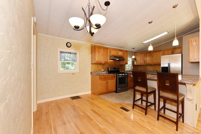 107 Colchester Commons, Colchester, CT 06415 - kitchen featuring gas stove, refrigerator with ice dispenser, under cabinet range hood, light wood-style flooring, and a kitchen breakfast bar