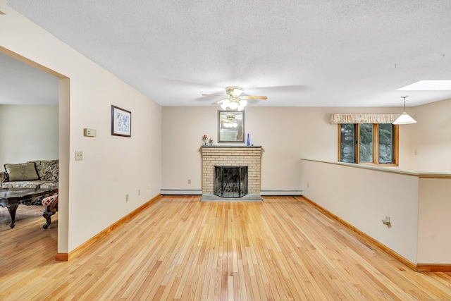 9 Cypress Ln, Trumbull, CT 06611 - unfurnished living room featuring a baseboard heating unit, light wood-type flooring, a ceiling fan, baseboards, and a textured ceiling