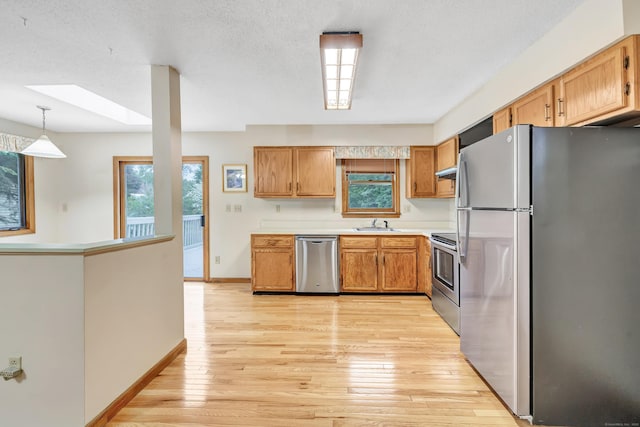 9 Cypress Ln, Trumbull, CT 06611 - kitchen featuring appliances with stainless steel finishes, a skylight, baseboards, light wood-style flooring, and light countertops