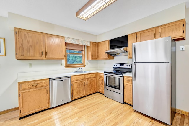 9 Cypress Ln, Trumbull, CT 06611 - kitchen featuring appliances with stainless steel finishes, a sink, light wood-style flooring, light countertops, and under cabinet range hood
