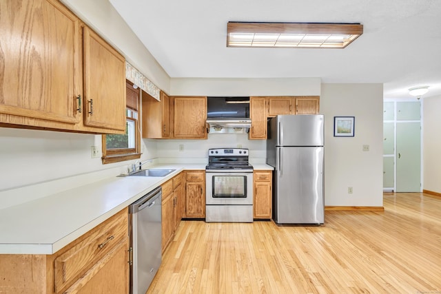 9 Cypress Ln, Trumbull, CT 06611 - kitchen with stainless steel appliances, a sink, light wood-style floors, light countertops, and extractor fan