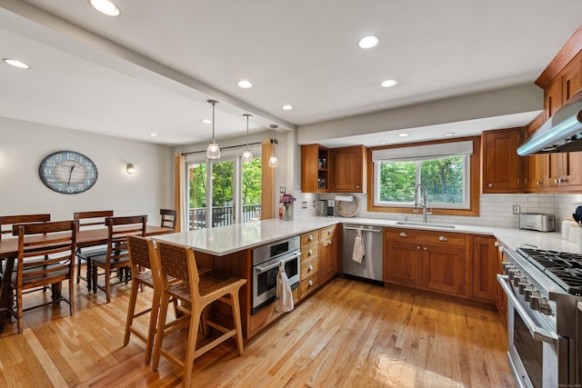 19 Huckleberry Dr S, Norwalk, CT 06850 - kitchen with stainless steel appliances, a sink, open shelves, brown cabinetry, and a peninsula
