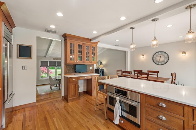 19 Huckleberry Dr S, Norwalk, CT 06850 - kitchen with brown cabinets, light wood-style flooring, light countertops, hanging light fixtures, and beamed ceiling