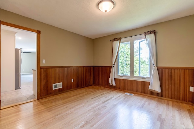 131 Spring Brook Dr, Middletown, CT 06457 - spare room with wainscoting, light wood finished floors, and wood walls