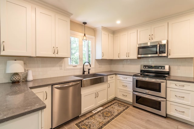 131 Spring Brook Dr, Middletown, CT 06457 - kitchen with stainless steel appliances, a sink, decorative backsplash, light wood-type flooring, and recessed lighting