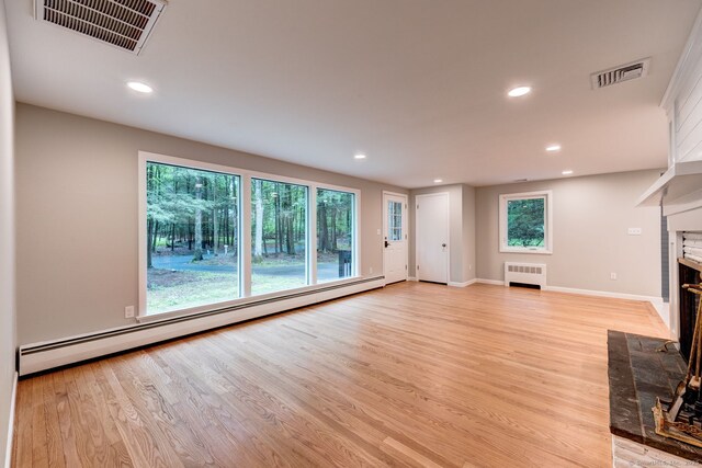 33 White Oak Ln, Woodbridge, CT 06525 - unfurnished living room with radiator heating unit, a baseboard heating unit, light wood-type flooring, a fireplace, and recessed lighting