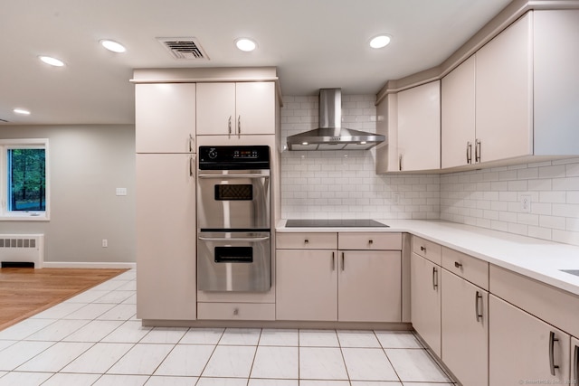 33 White Oak Ln, Woodbridge, CT 06525 - kitchen with wall chimney range hood, radiator heating unit, stainless steel double oven, light countertops, and backsplash