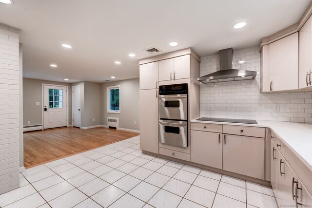 33 White Oak Ln, Woodbridge, CT 06525 - kitchen with wall chimney exhaust hood, stainless steel double oven, radiator heating unit, black electric stovetop, and light countertops