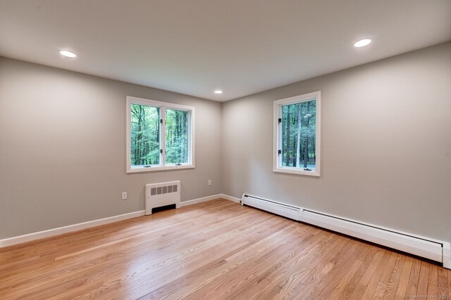 33 White Oak Ln, Woodbridge, CT 06525 - empty room featuring radiator heating unit, a baseboard heating unit, light wood-style floors, recessed lighting, and baseboards