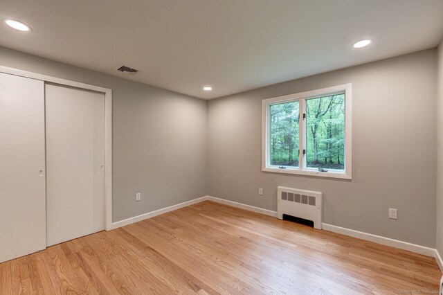 33 White Oak Ln, Woodbridge, CT 06525 - unfurnished bedroom with radiator heating unit, light wood-style floors, recessed lighting, baseboards, and a closet
