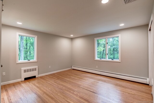 33 White Oak Ln, Woodbridge, CT 06525 - empty room featuring radiator, baseboard heating, light wood-style flooring, baseboards, and recessed lighting