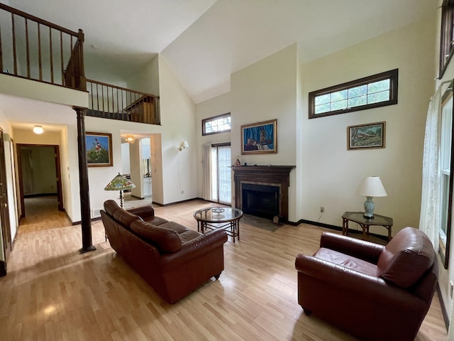 1433 Naugatuck Ave Unit 1433, Milford, CT 06461 - living area featuring high vaulted ceiling, light wood-style flooring, a fireplace with flush hearth, and baseboards