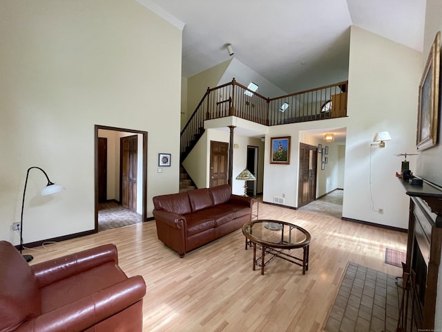 1433 Naugatuck Ave Unit 1433, Milford, CT 06461 - living area featuring light wood-style floors, a towering ceiling, stairs, and baseboards