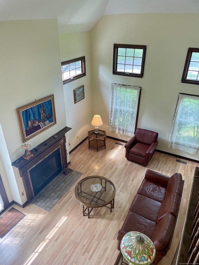 1433 Naugatuck Ave Unit 1433, Milford, CT 06461 - living area featuring a fireplace with flush hearth, high vaulted ceiling, wood finished floors, and baseboards