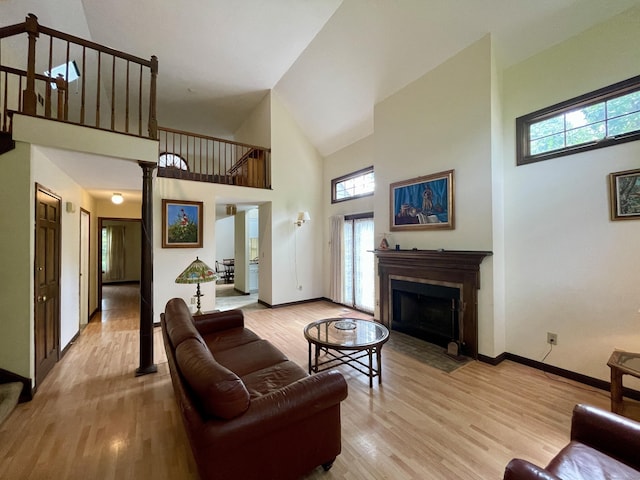 1433 Naugatuck Ave Unit 1433, Milford, CT 06461 - living area with high vaulted ceiling, wood finished floors, a fireplace with flush hearth, baseboards, and stairs