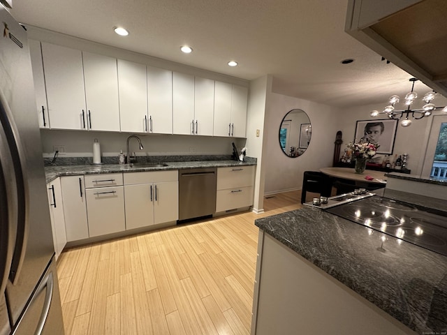 12 Spindle Hill Rd Apt 8A, Wolcott, CT 06716 - kitchen with stainless steel appliances, recessed lighting, light wood-style floors, white cabinetry, and dark stone counters