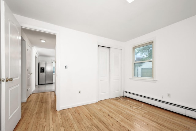 166 Wynola Ave, New Britain, CT 06051 - unfurnished bedroom with stainless steel refrigerator with ice dispenser, baseboard heating, light wood finished floors, a closet, and baseboards