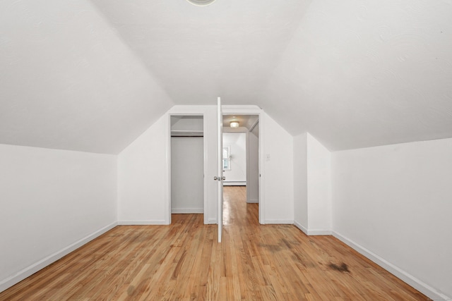 166 Wynola Ave, New Britain, CT 06051 - bonus room featuring light wood-style floors, baseboards, vaulted ceiling, and a baseboard radiator