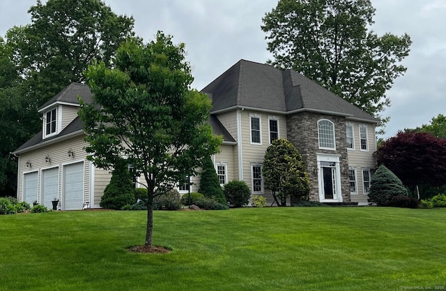 37 Ellsworth Ln, Ellington, CT 06029 - view of front of house with stone siding, a front yard, and a garage