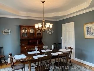37 Ellsworth Ln, Ellington, CT 06029 - dining room with a raised ceiling, ornamental molding, a chandelier, wood finished floors, and baseboards