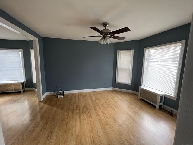 48 Moore Ave, New London, CT 06320 - empty room featuring radiator heating unit, a ceiling fan, light wood finished floors, and baseboards